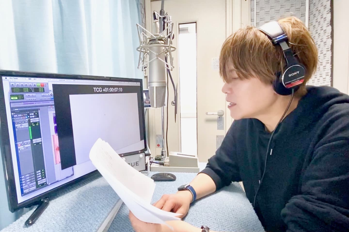 ごりっぱスタジオの収録ブース内部で、モニタに向かってナレーション収録をする男性